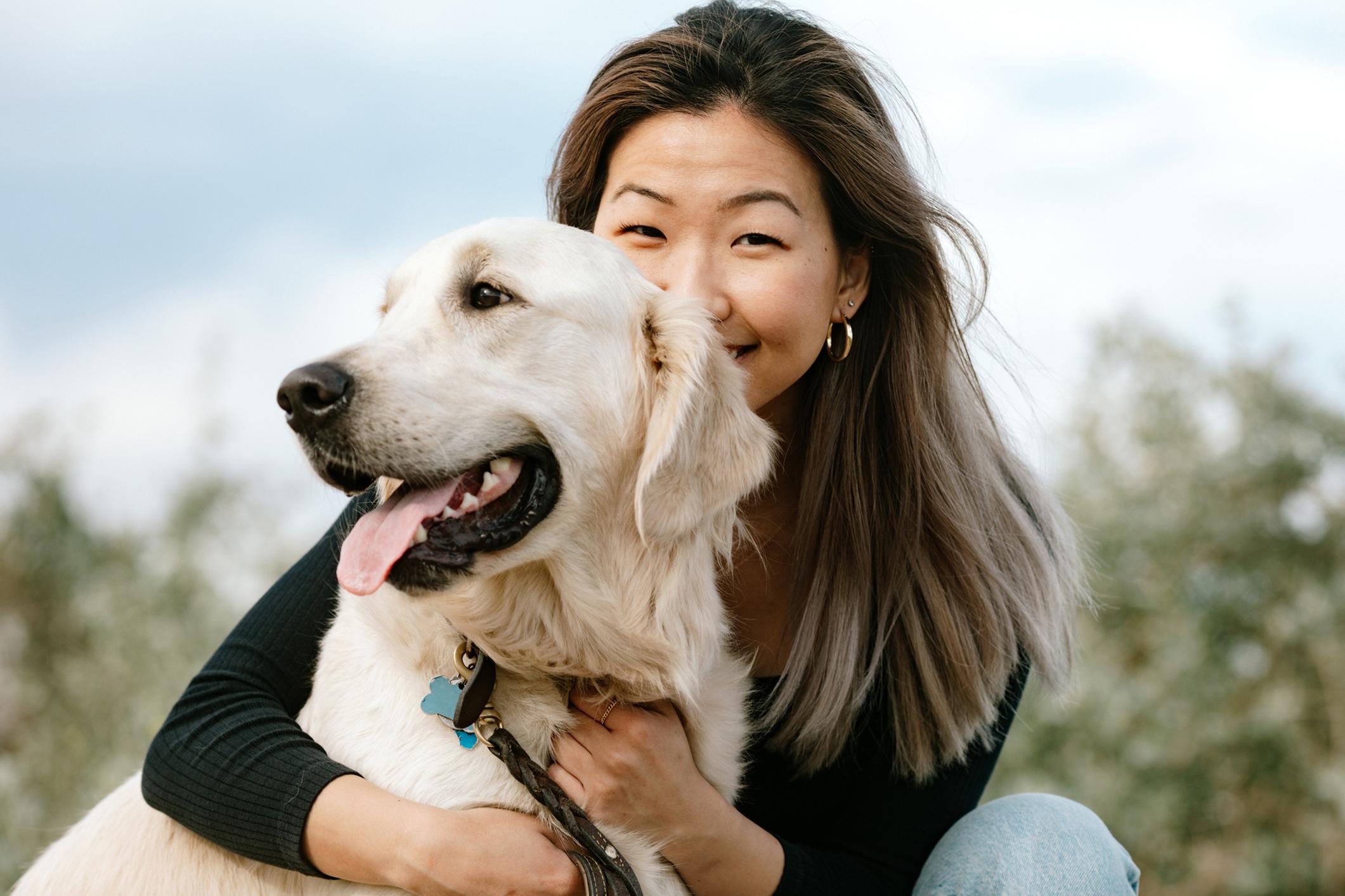 Asian Woman Hugging Her Dog Outdoors