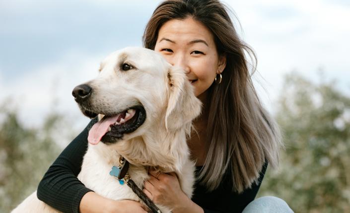 Asian Woman Hugging Her Dog Outdoors